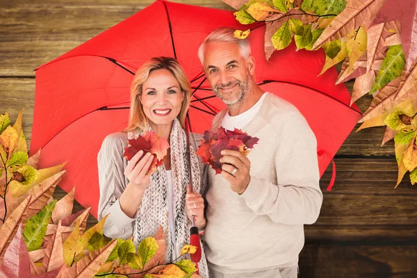 Retrato de casal feliz sob guarda-chuva vermelho — Fotografia de Stock