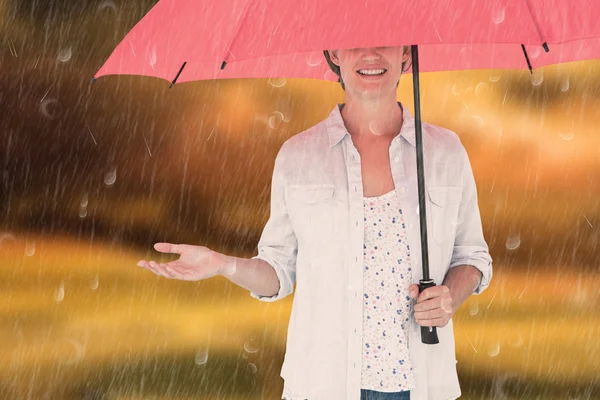 Composite image of woman holding an umbrella — Stock Photo, Image