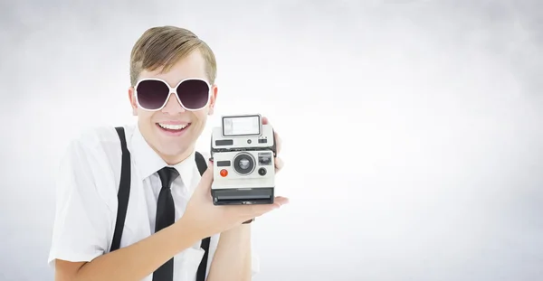 Geeky hipster holding a retro camera — Stock Photo, Image