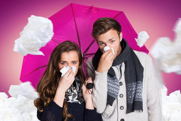 Paar pustet Nase aus, während es Regenschirm hält — Stockfoto