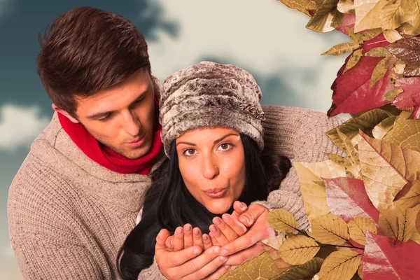 Pareja joven soplando sobre las manos — Foto de Stock