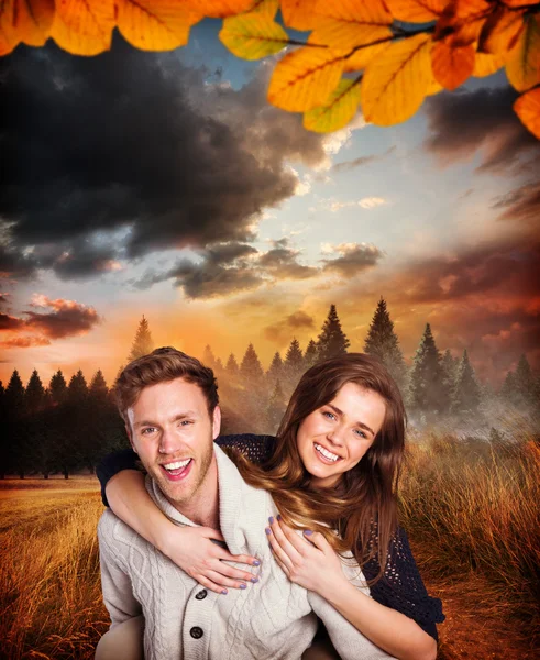 Smiling young man carrying woman — Stock Photo, Image