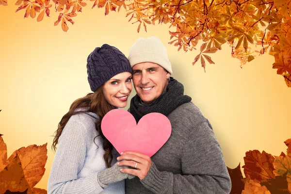 Счастливая пара в теплой одежде с сердцем — стоковое фото