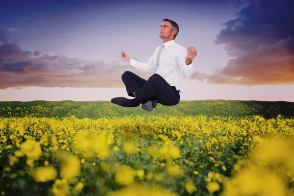 Peaceful businessman sitting in lotus pose — Stock Photo, Image