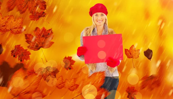 Blonde in winter clothes holding red sign — Stock Photo, Image