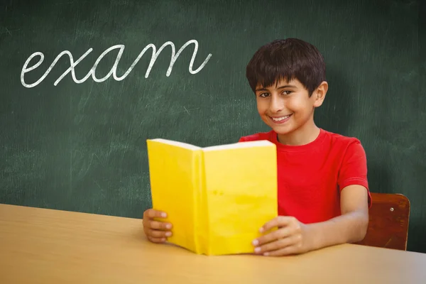 Word exam and schoolboy reading book — Stock Photo, Image