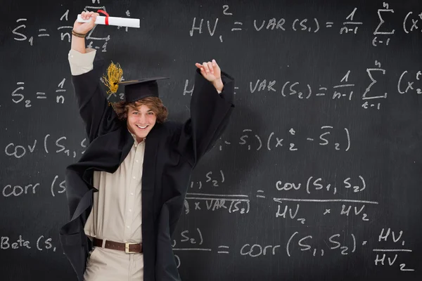 Male student in graduate robe jumping — Stock Photo, Image