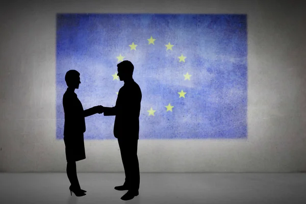 Composite image of silhouettes shaking hands — Stock Photo, Image