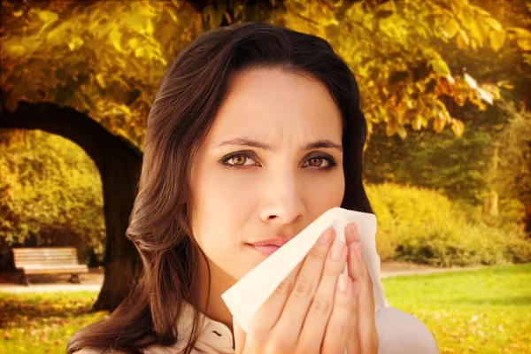 Composite image of brunette with a cold — Stock Photo, Image