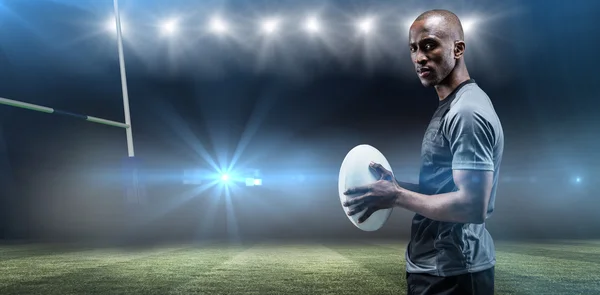 Kendine güvenen atlet ile rugby topu ayakta — Stok fotoğraf