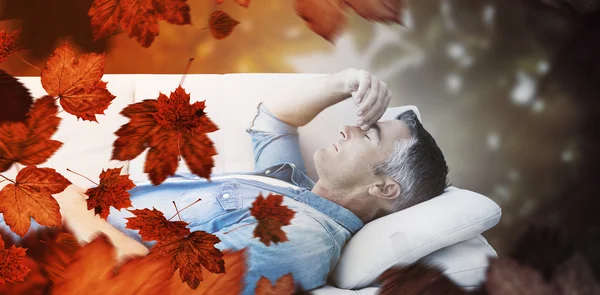 Uomo che soffre di mal di testa mentre sul divano — Foto Stock