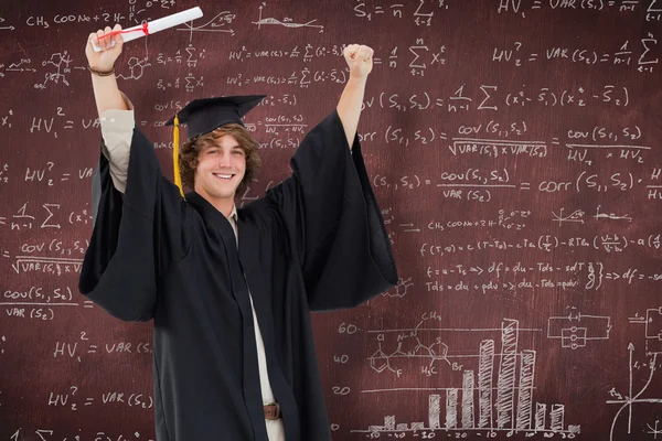 Estudiante masculino en bata de graduado levantando su brazo —  Fotos de Stock