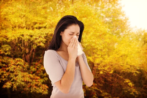 Sick brunette blowing her nose — Stock Photo, Image