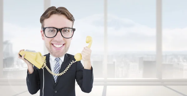 Composite image of geeky businessman holding phone — Stock Photo, Image