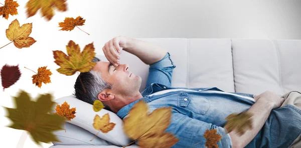 Man suffering from headache while on sofa — Stock Photo, Image