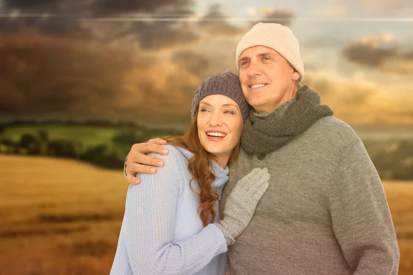Immagine composita di coppia in abiti caldi abbracciando — Foto Stock