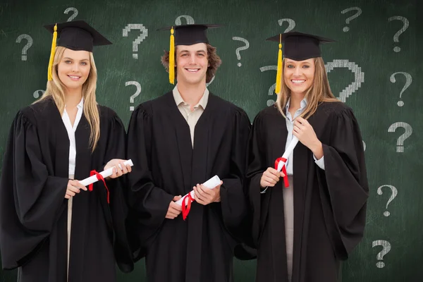 Tre studenter i forskarutbildning mantel innehar ett examensbevis — Stockfoto