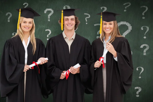 Tres estudiantes con bata de graduado con diploma — Foto de Stock