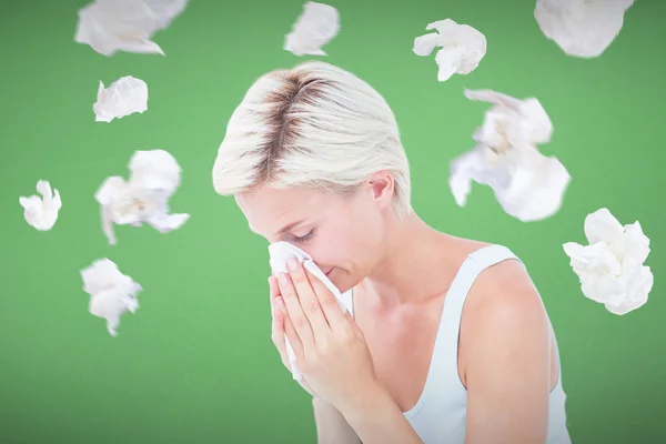 Composite image of sick woman blowing her nose — Stock Photo, Image