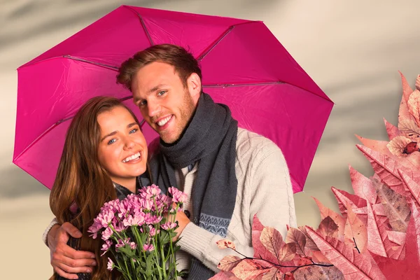 Joyeux jeune couple avec des fleurs et parapluie — Photo