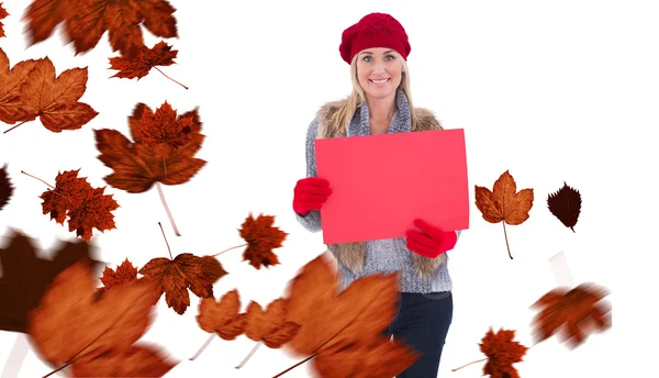 Blonde in winter clothes holding red sign — Stock Photo, Image