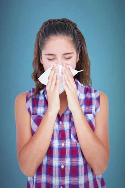 Beautiful woman sneezing in a tissue — Stock Photo, Image