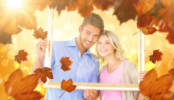 Atraente jovem casal segurando quadro de imagem — Fotografia de Stock