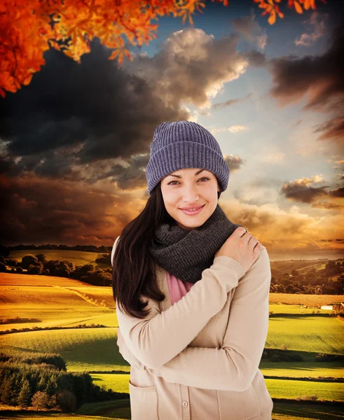 Composite image of attractive brunette looking at camera wearing — Stock Photo, Image