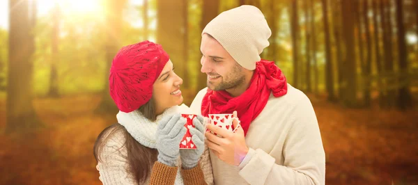 Pareja de invierno sosteniendo tazas — Foto de Stock