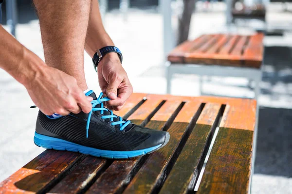 Athletic man tying his shoelaces — Stock Photo, Image