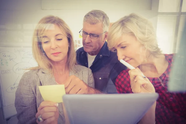 Attentive business team looking at a post it — Stock Photo, Image