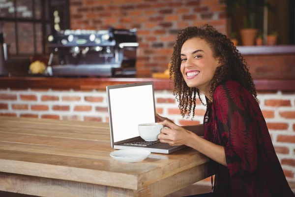 Morena tomando café usando laptop — Foto de Stock