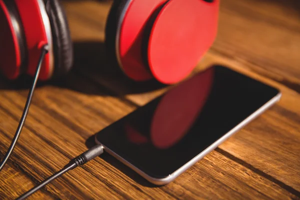 Mesa com fones de ouvido e telefone — Fotografia de Stock