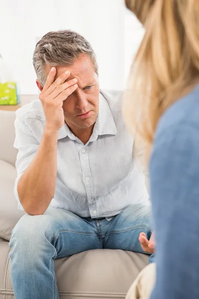 Worried man sitting on couch a — Stock Photo, Image