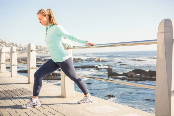 Fit blonde stretching on railing — Stock Photo, Image