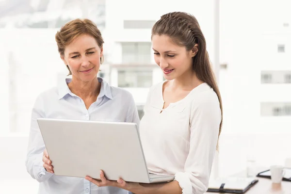 Leende affärskvinnor med laptop — Stockfoto