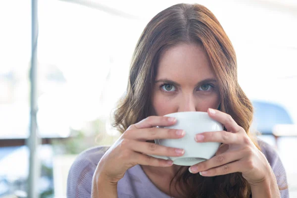 Morena bonita desfrutando de um cappuccino — Fotografia de Stock