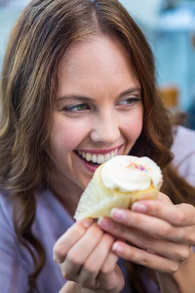 Mooie brunette genieten van een cake — Stockfoto