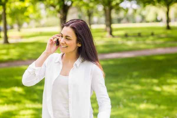 Brünette im Park telefoniert — Stockfoto