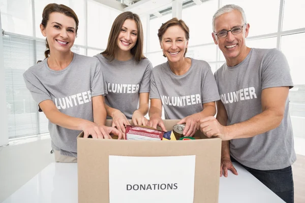 Vrijwilligers sorteren donatie box — Stockfoto