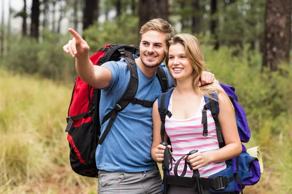 Pasangan pejalan kaki muda yang bahagia menunjuk — Stok Foto