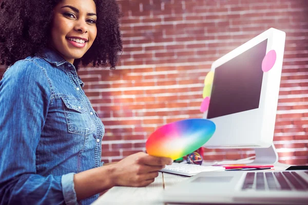 Designer lächelt und hält Farbkarte in der Hand — Stockfoto