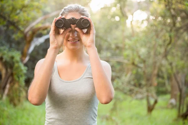 Brunette looking through binoculars — Stock Photo, Image