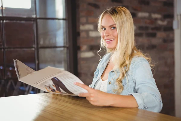Усміхнена блондинка тримає газету — стокове фото