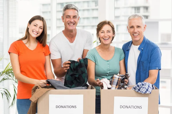 Business people sorting donation boxes — Stock Photo, Image