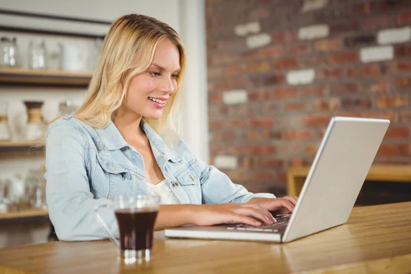 Smiling blonde  using laptop — Stock Photo, Image