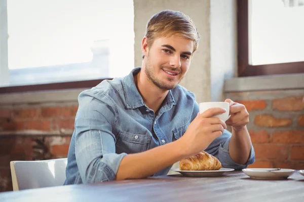 Uomo godendo caffè e croissant — Foto Stock