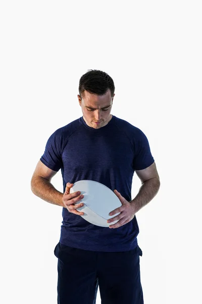 Homem atento segurando uma bola de rugby — Fotografia de Stock