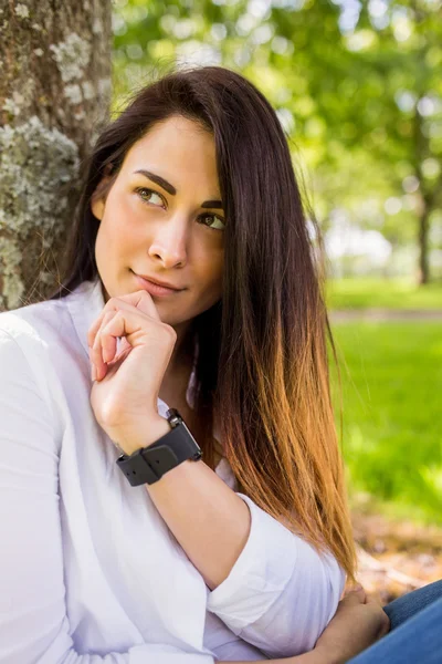 Brunette denken in het park — Stockfoto