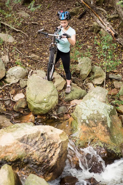 Mujer en forma levantando su bicicleta — Foto de Stock